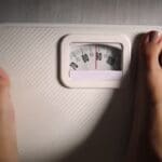 standing on scales to measure weight loss