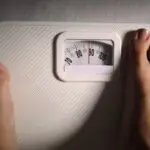 standing on scales to measure weight loss