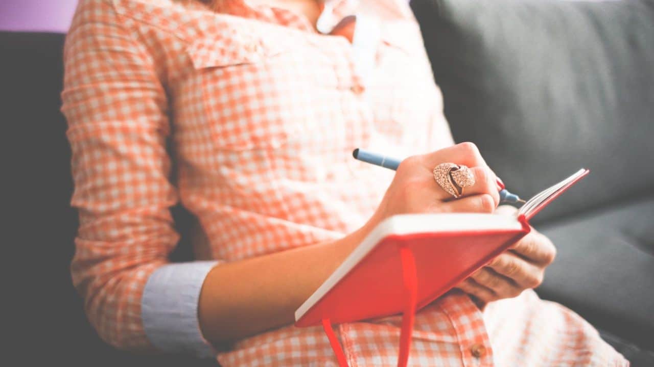 Woman writing in a journal to help relieve stress